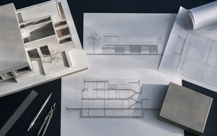 A concrete sample model beside architectural drawings