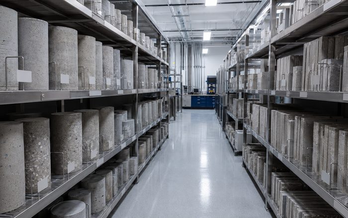 Laboratory storage racks holding labeled concrete cylinders and panel samples