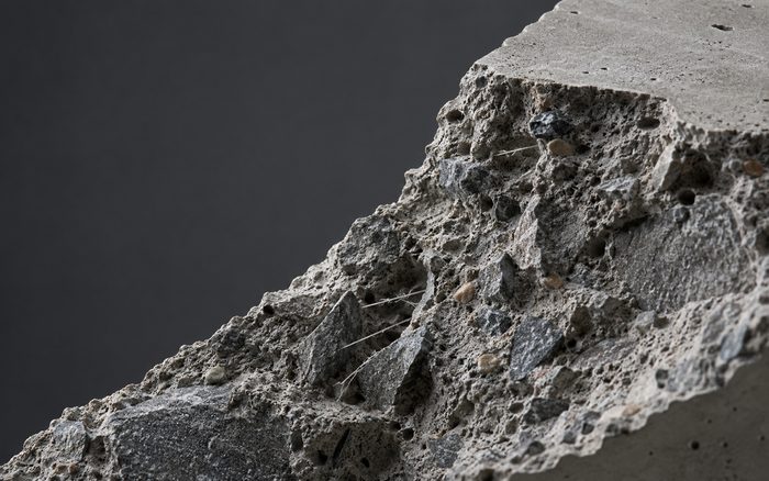 Fractured concrete revealing aggregate and reinforcing fibers